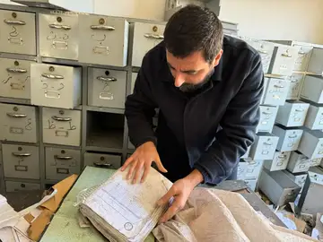 عامر مطر يفحص سجلات الاعتقال وسط خزائن الملفات في سوريا